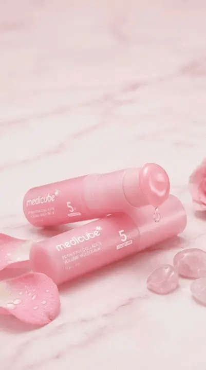 Two pink collagen volume multi balm sticks on a marble surface